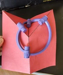 Folha de papel vermelho com dobraduras de origami.